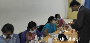 Dr Dayanand teaching students with loupes