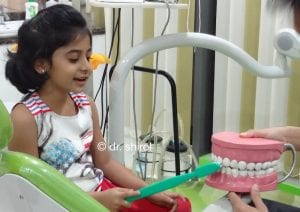 Dr Dayanand teaching brushing technique to child